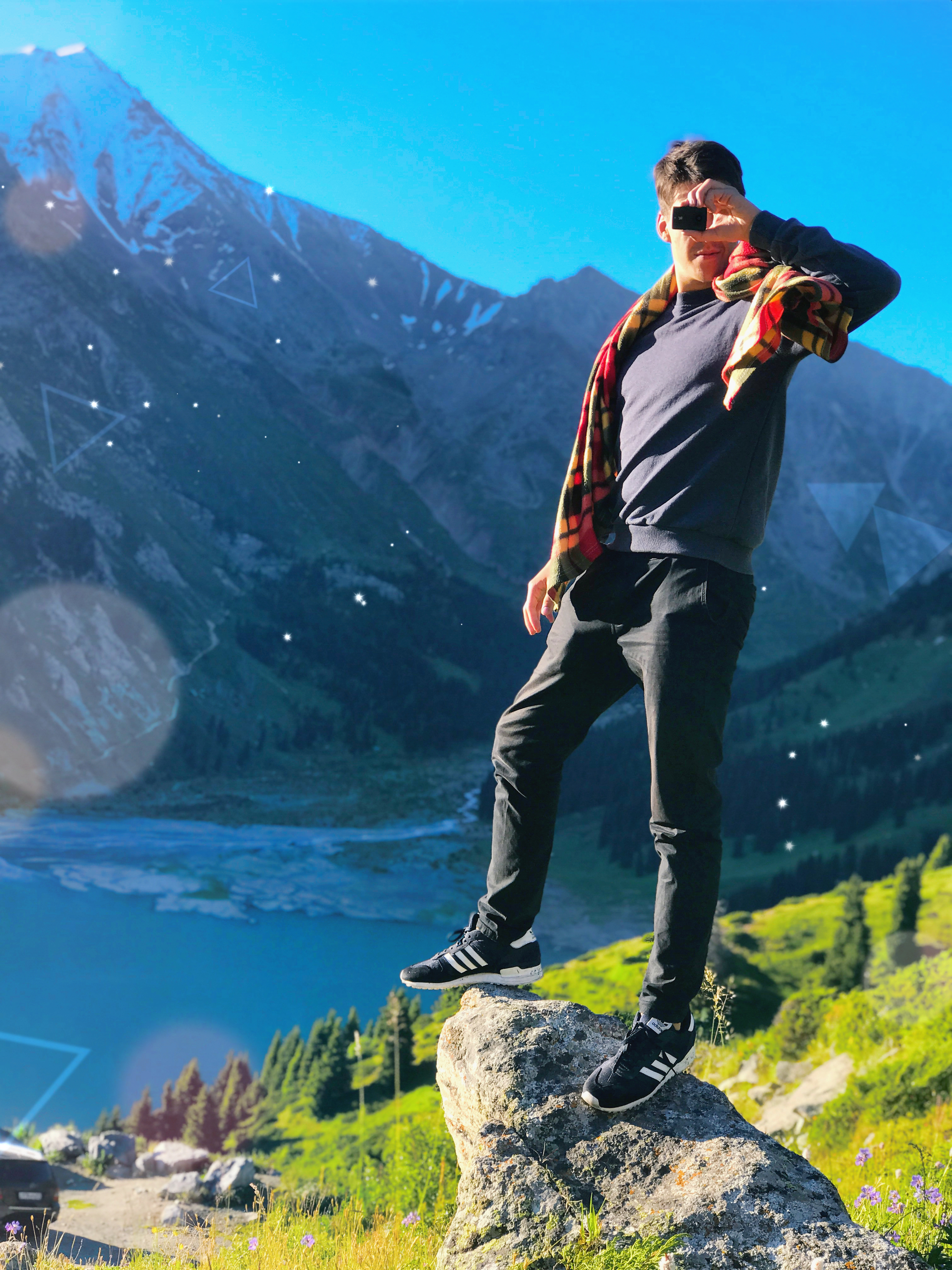 Traveller photographing the mountain landscape above Big Almaty Lake