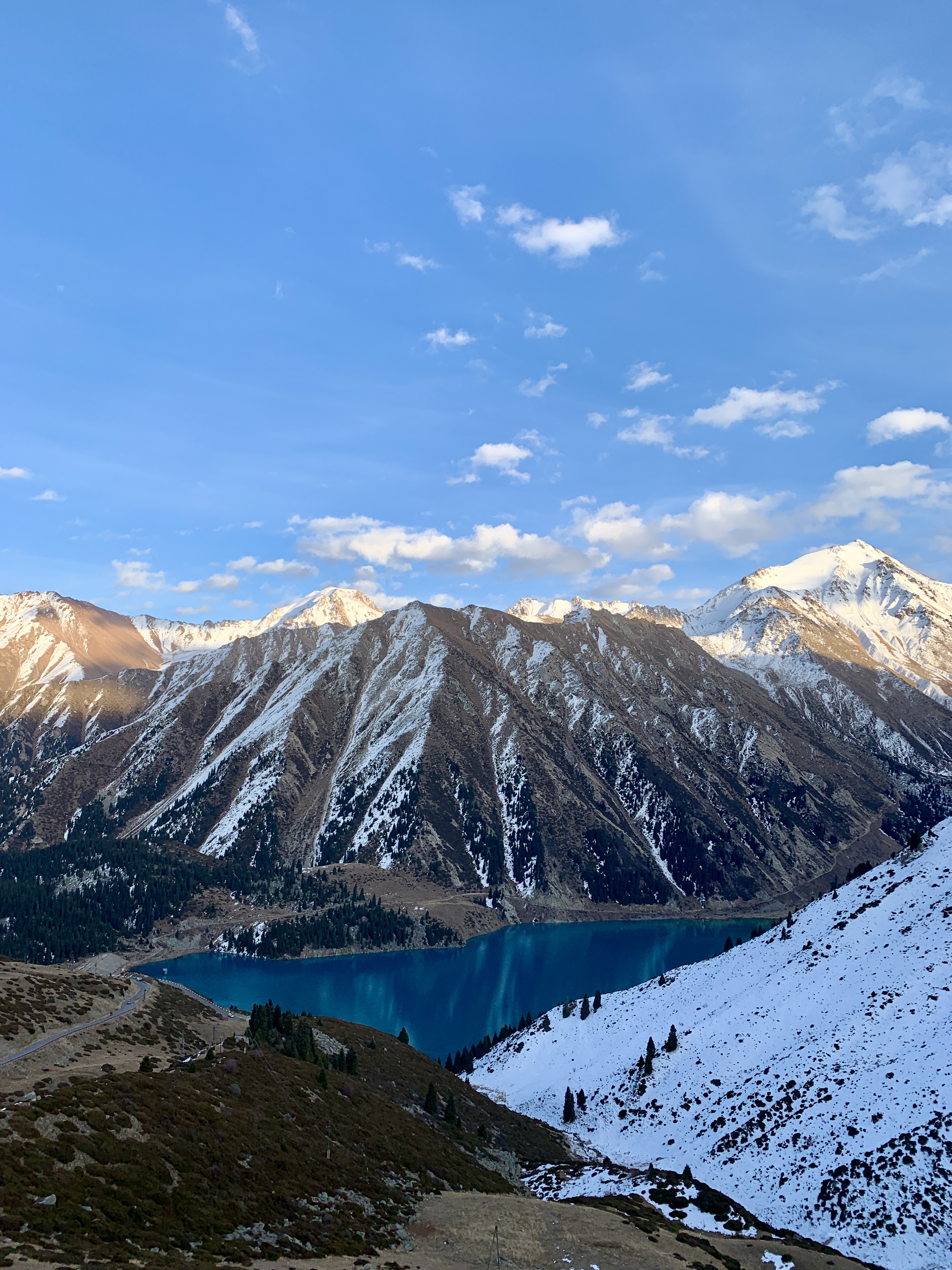 Big Almaty Lake seen between snow-covered mountain ridges