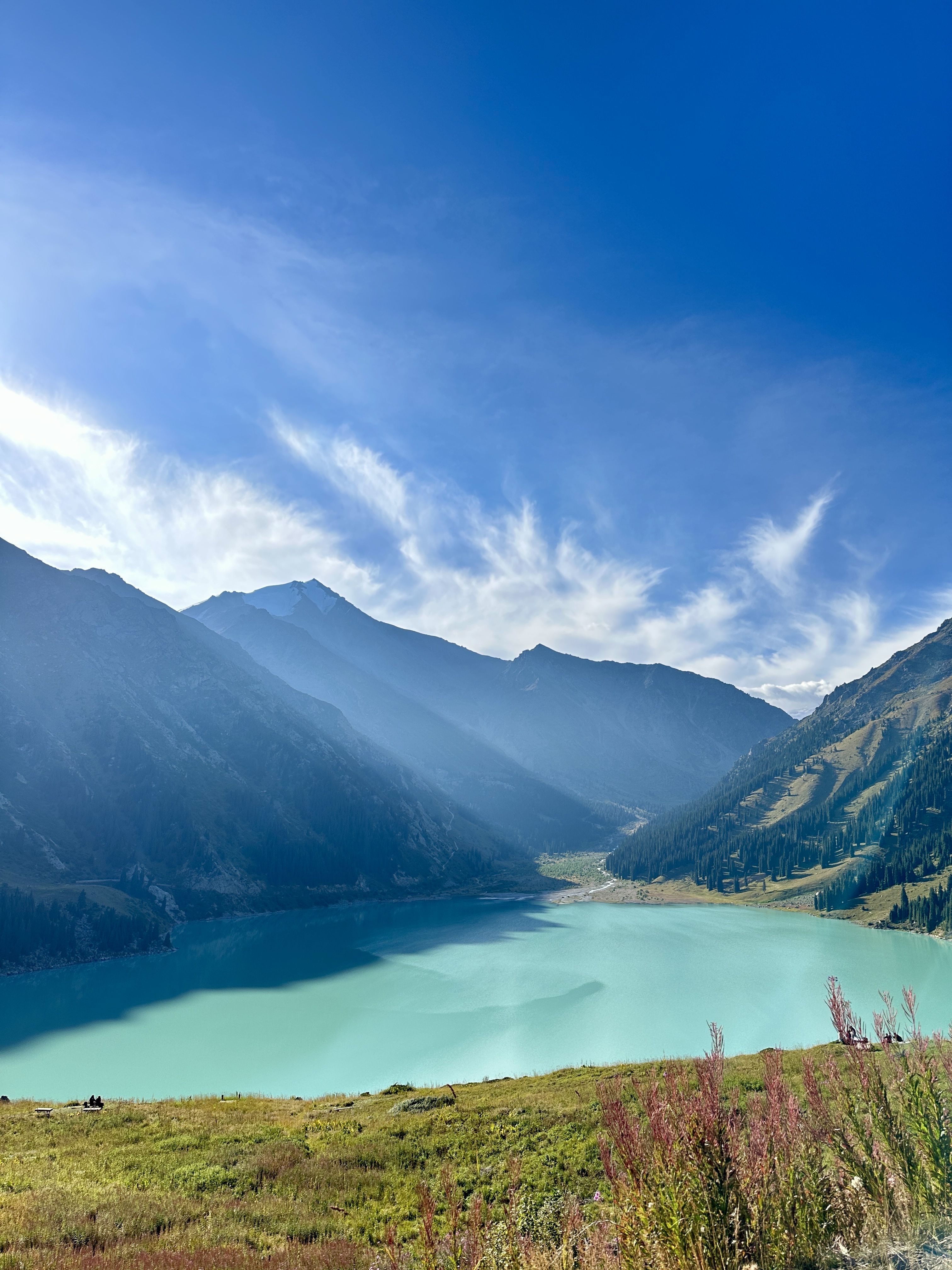Big Almaty Lake beneath mountain ridges and a deep blue summer sky