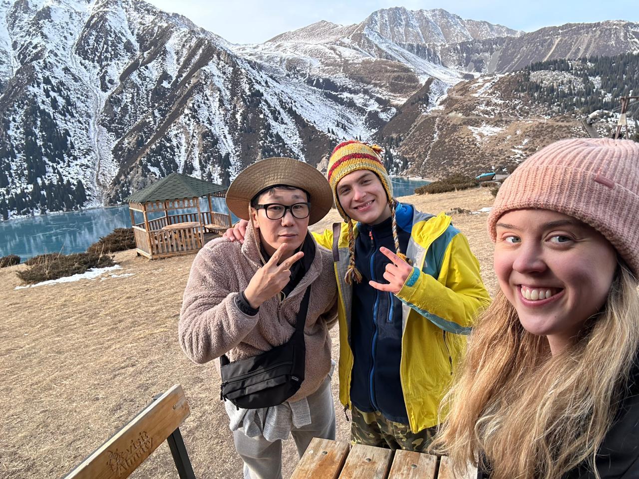 Travellers taking a joyful selfie with their guide near Big Almaty Lake