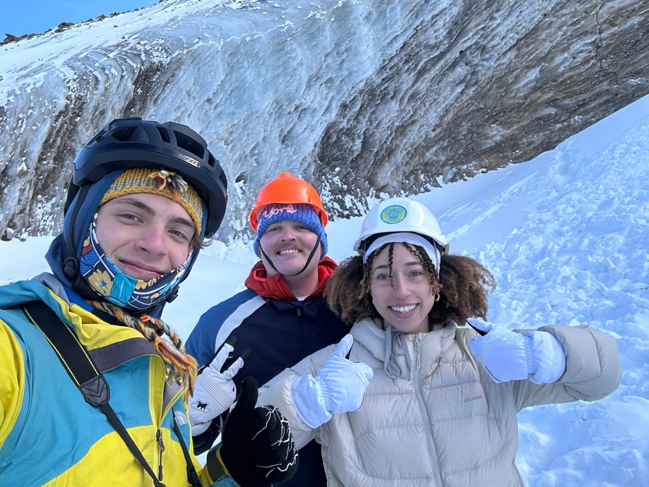 Two winter travellers and their guide on a snowy mountain experience