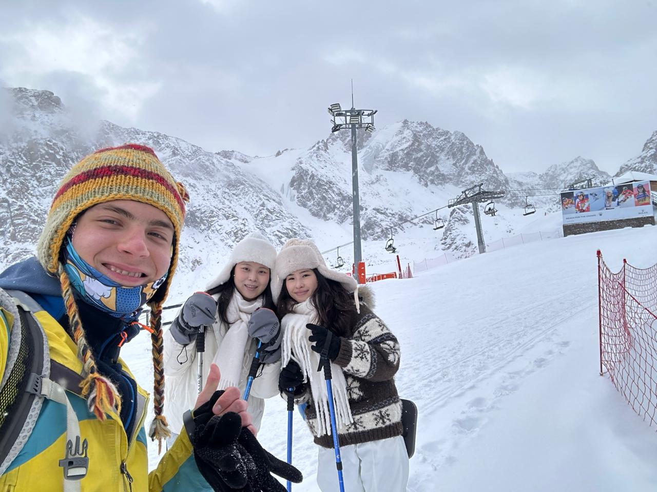 Two guests with their guide in the snowy Almaty mountains